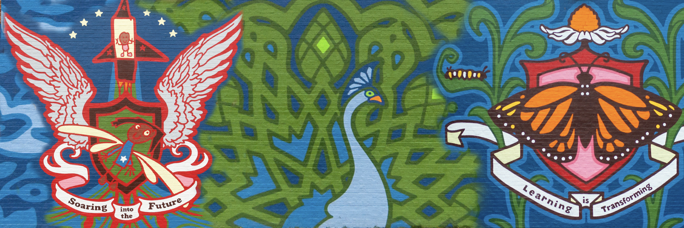 Colorful mural at Benjamin B. Comegys School featuring a rocket with wings, a peacock, and a monarch butterfly symbolizing growth, learning, and transformation.